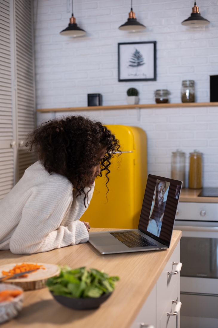 Focused black girl making video call on netbook